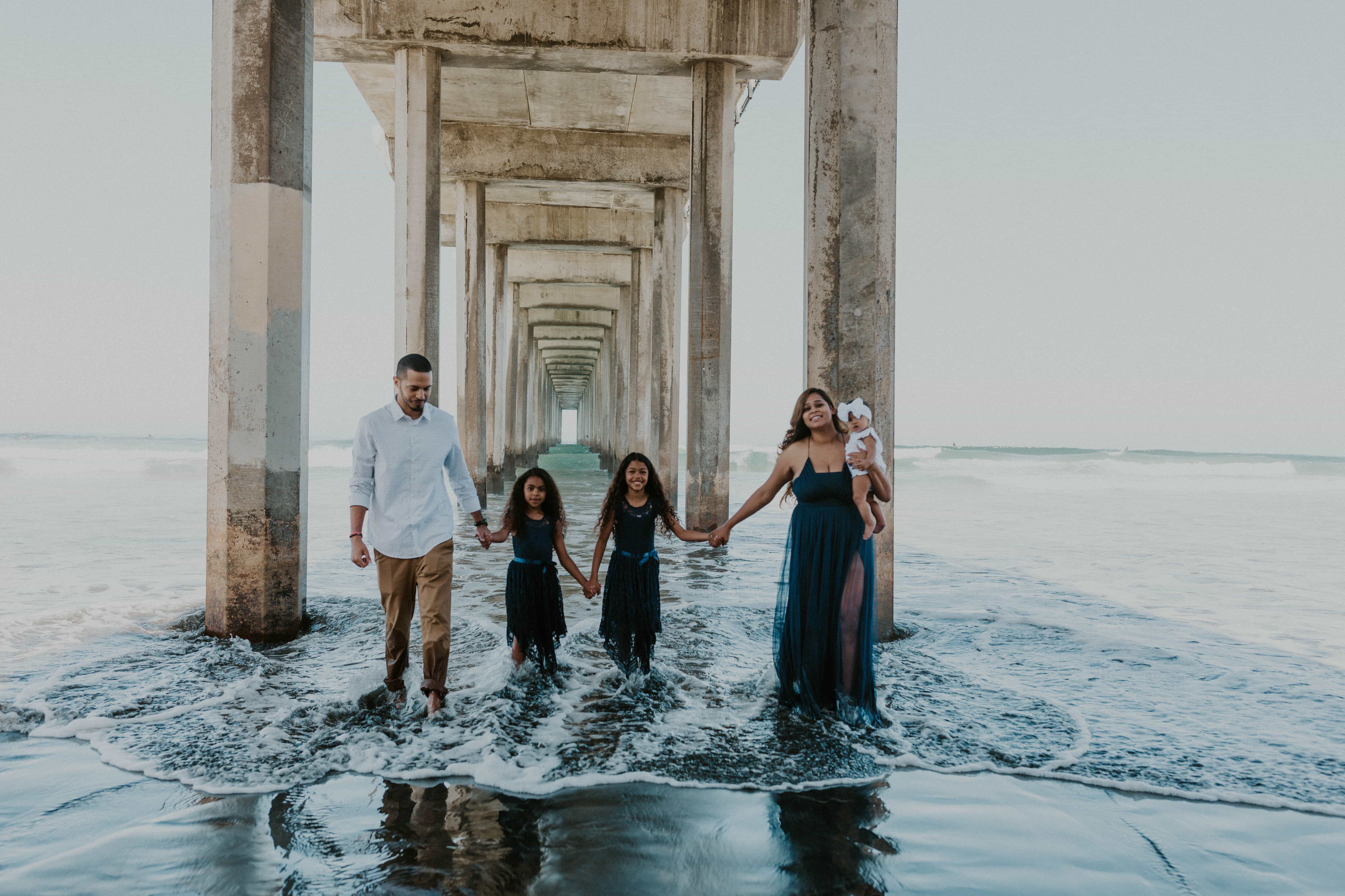 Jason and Jessika with their daughters under Scripps Pier in San Diego